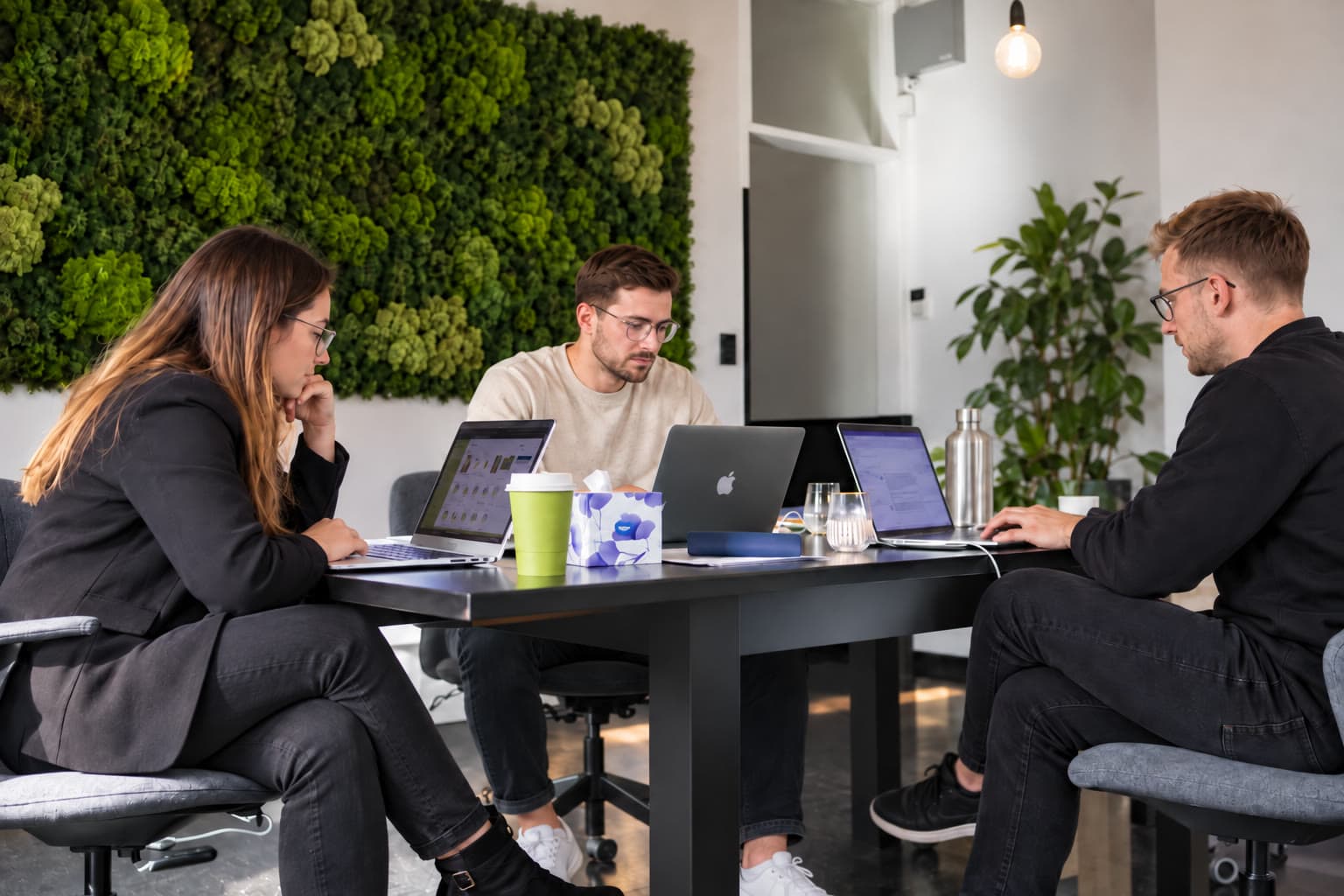 Google Ads Agentur Dresden – das ClickScale-Team optimiert im Büro gemeinsam Google-Ads-Kampagnen, drei Personen mit Laptops am Besprechungstisch